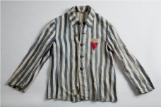 Kabát vězně koncentračního tábora s označením T (označení pro Čechoslováky)v červeném trojúhelníku